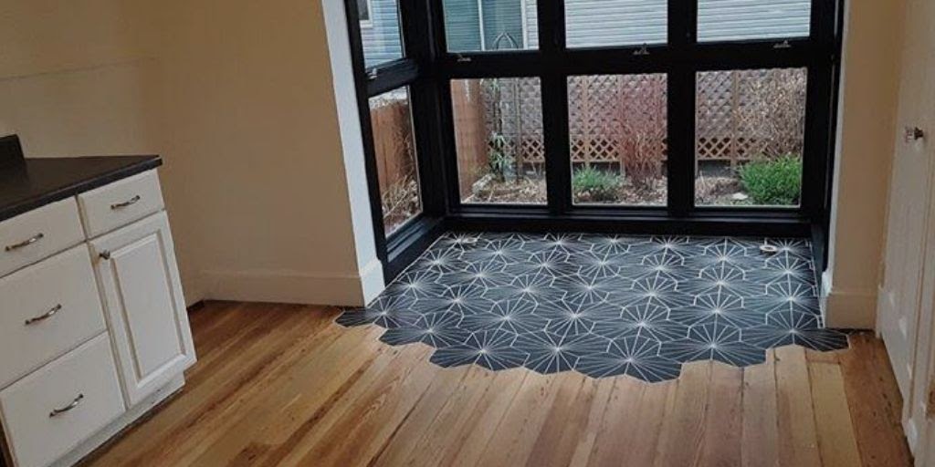kitchen with black mosaic tile transitioning into hardwood flooring